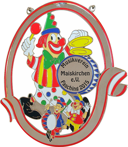 Karnevalsorden Silber „Clown mit Trommel“ – Vorderansicht mit bunten Clownmotiven Silberfarbener Karnevalsorden „Clown mit Trommel“ mit rot umrandetem Rahmen, Aussparungen und bunten Clownmotiven. Das runde Mittelfeld trägt die Aufschrift „Musikverein Maiskirchen e.V. Fasching 2015“.