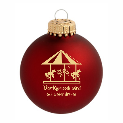 Karussell Weihnachtskugel aus Glas mit Karussellmotiv Rote Weihnachtskugel aus Glas mit Karussellmotiv und dem Schriftzug „Das Karussell wird sich weiter drehen“, mit goldfarbener Aufhängung und matter Oberfläche.