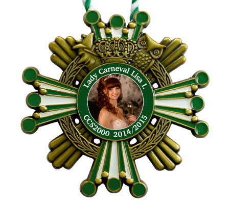 Karnevalsorden in Antikbronze mit Krone, Ehrenkranz und grün-weißen Strahlen. In der Mitte ein Porträt einer Frau mit der Aufschrift „Lady Carneval Lisa I.“ und „CCS2000 2014/2015“. Oben eine grün-weiße Kordel.