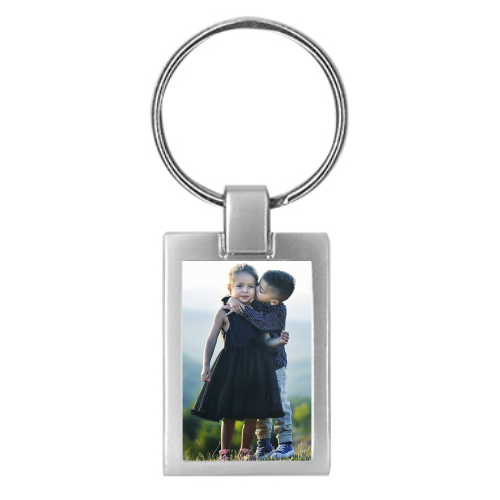 Metall-Schlüsselanhänger mit individuellem Fotodruck Rechteckiger Metall-Schlüsselanhänger mit mattem Finish und Schlüsselring, bedruckt mit einem hochformatigen Foto von zwei Kindern.
