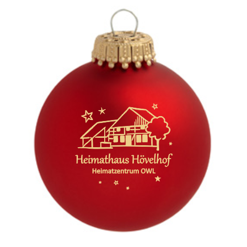 Hövelhof Heimathaus Weihnachtskugel aus rotem Glas mit Heimathaus-Motiv Rote Weihnachtskugel aus Glas mit goldfarbenem Druck des Heimathauses Hövelhof und dem Schriftzug „Heimathaus Hövelhof Heimatzentrum OWL“, mit goldfarbener Aufhängung.