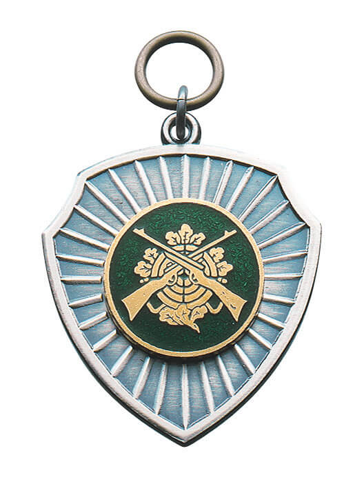 Anhänger vergoldet mit grün-goldener Auflage Zielscheibe und Gewehre Spitz zulaufender Anhänger vergoldet mit Randverzierung, silberfarbener Strahlenfläche und runder grün-goldener Auflage mit Zielscheibe und gekreuzten Gewehren, mit Öse und Ring