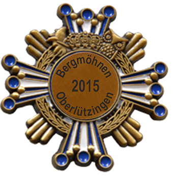 Karnevalsabzeichen Altgold mit Krone und Eule, rundes Emblem 2015 Karnevalsabzeichen in Altgold mit rundem Emblem, Krone, Eulenmotiv und blau-weißen Strahlen, mittig beschriftet mit Bergmöhnen Oberlützingen 2015