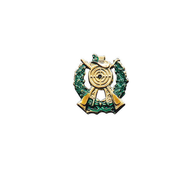 Abzeichen vergoldet mit langer Nadel, Schützensymbol mit Zielscheibe, Gewehren und grünem Kranz Vergoldetes Abzeichen mit langer Nadel in Form eines Schützensymbols mit Zielscheibe, gekreuzten Gewehren, Hut und grünem Kranz.