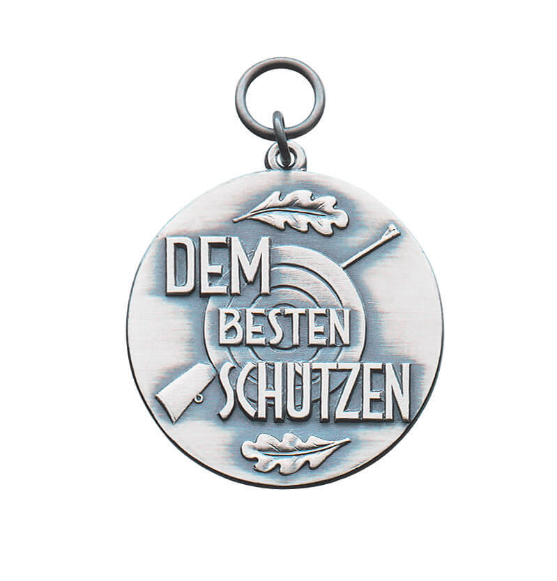 Medaille für Schützen mit Schriftzug Dem besten Schützen und Zielscheibenmotiv Runde Medaille für Schützen mit Öse und Ring, Schriftzug „Dem besten Schützen“, Zielscheibe, Gewehr und zwei Eichenlaubblättern auf der Vorderseite.