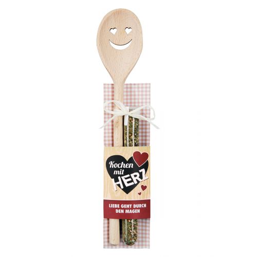 Holz Kochlöffel mit Herzmotiv und Chimichurri Gewürzmischung Holz Kochlöffel mit ausgeschnittenem Herz- und Lachgesicht, zusammen mit einer Chimichurri Gewürzmischung im Reagenzglas auf karierter Karte mit Aufdruck Kochen mit Herz