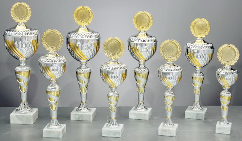 Pokal Mintha silber / gold, Serie mit acht Pokalen Acht Pokale der Serie Mintha in Silber und Gold mit runder Schale, Deckel, goldenem Emblem und weißem Marmorsockel; abgebildet ist die Variante Pokal Mintha silber / gold H 477 mm / D 140 mm im Serienbild.