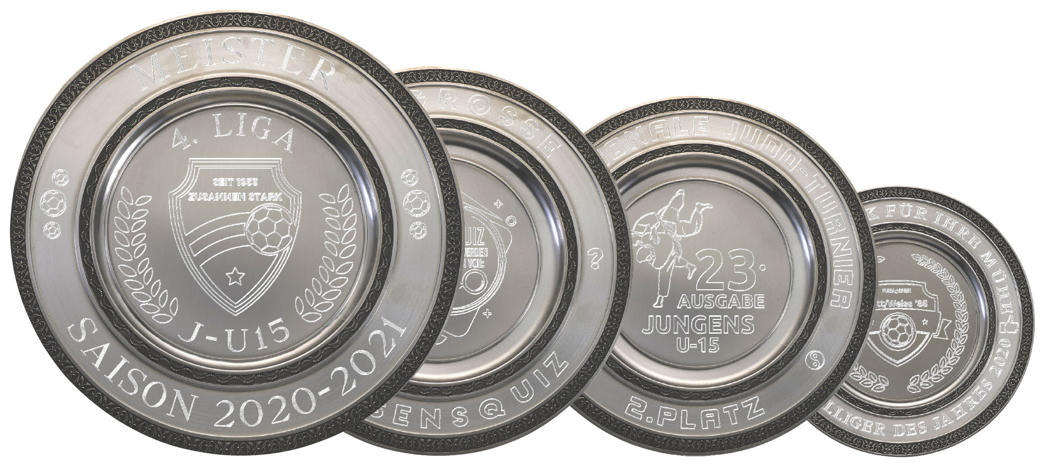 Kontrastreicher Ehrenteller mit Gravur in runder Form mit Fußballmotiven Vier kontrastreiche Ehrenteller mit Gravur in runder Form, silberfarbener Optik und dunklem Randdekor, mit eingravierten Fußballmotiven, Schriftzügen und Platzierungsangaben.