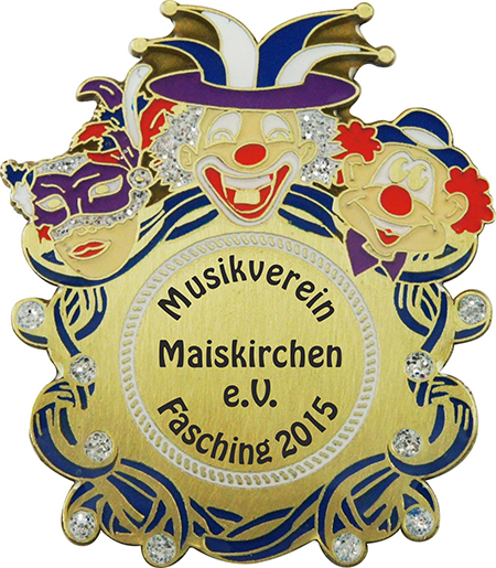 Karnevalsabzeichen Bronze Schild mit Luftschlangen und Clownsmotiven Karnevalsabzeichen in Bronzeoptik in Schildform mit Luftschlangen, zwei Clownsgesichtern und Maske. In der runden Mitte steht der Aufdruck „Musikverein Maiskirchen e.V. Fasching 2015“.