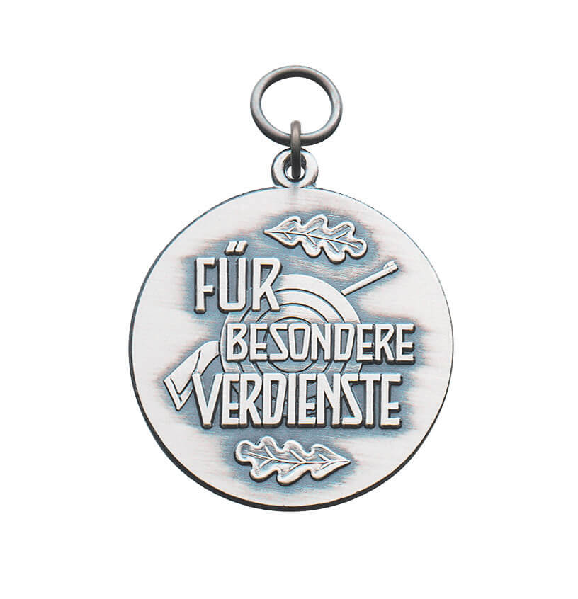 Medaille für besondere Verdienste mit Zielscheibe und Eichenblättern Runde Medaille für besondere Verdienste als Anhänger in silberfarbener Optik, mit erhabenem Schriftzug „Für besondere Verdienste“, Zielscheibe im Hintergrund und zwei Eichenblättern.
