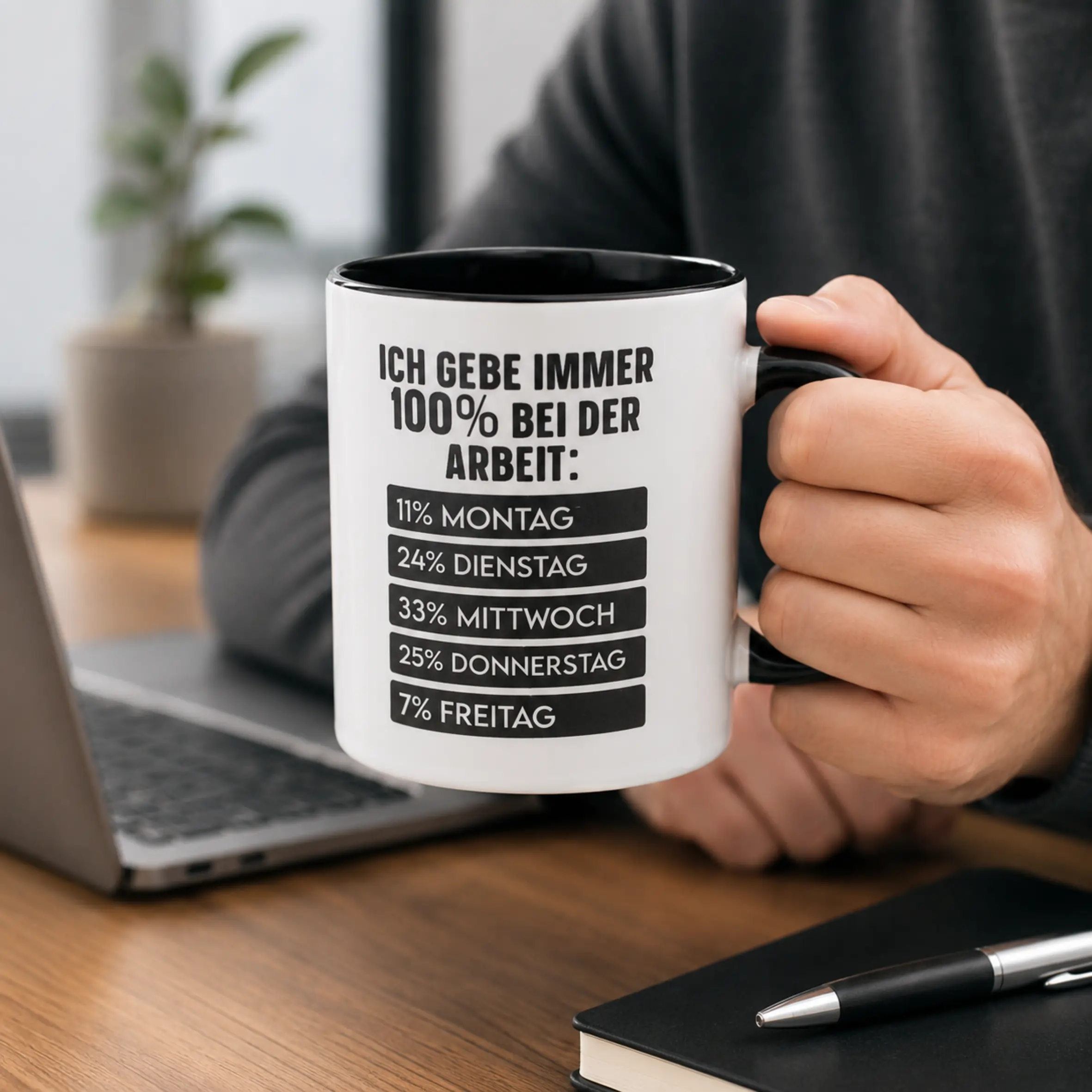 Tasse 100% bei der Arbeit mit schwarzem Henkel und Wochenprozent-Motiv Weiße Tasse 100% bei der Arbeit mit schwarzem Henkel und schwarzem Innenrand, bedruckt mit dem Spruch „Ich gebe immer 100% bei der Arbeit“ und einer Auflistung der Prozentwerte von Montag bis Freitag.
