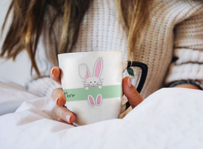 Weiße Tasse mit Hasenmotiv und Namen Marie Weiße Tasse mit schwarzem Henkel, grünem Streifen, Hasenmotiv und dem Namen Marie auf der Vorderseite