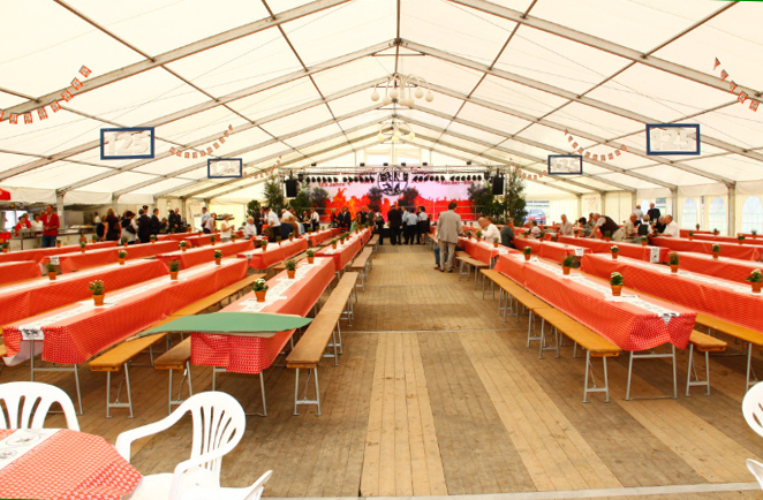 Tischdecke „Feuerwehr“ auf langen Biertischen im Festzelt Lange Festzeltgarnituren mit rot-weiß karierter Papier-Tischdecke „Feuerwehr“ auf Biertischen in einem Festzelt