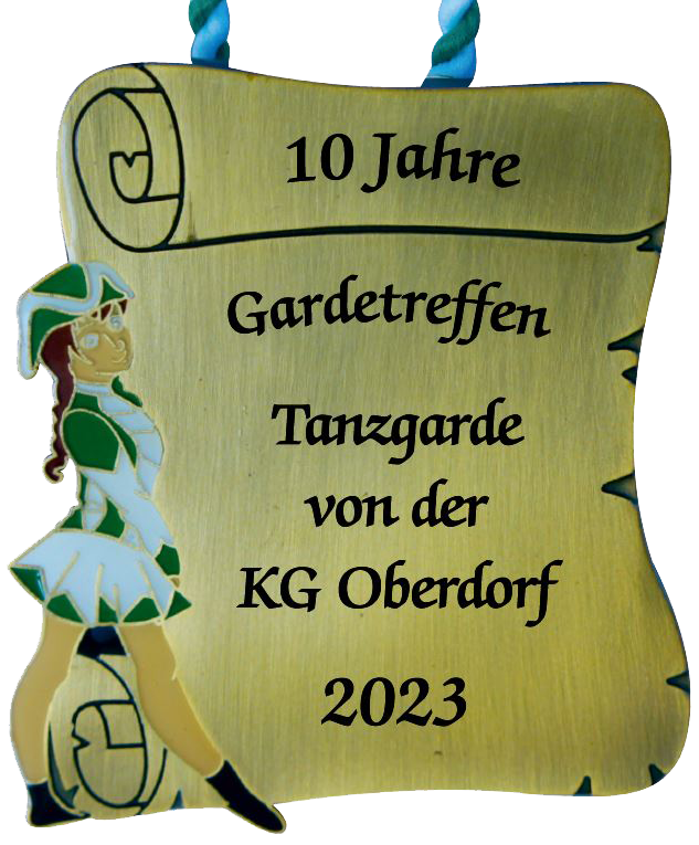 Karnevalsorden in Antikbronze-Optik als Schriftrolle mit grün-weißer Gardetänzerin am linken Rand und Kordelaufhängung. Schwarzer Aufdruck: „10 Jahre Gardetreffen Tanzgarde von der KG Oberdorf 2023“.