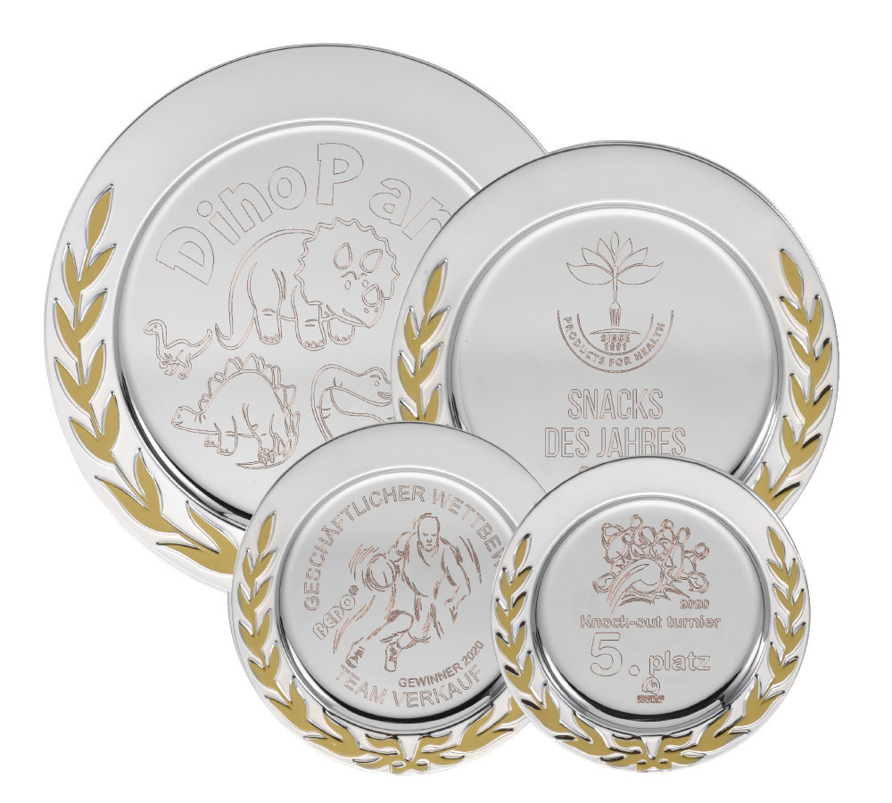 Ehrenteller „Ehrenkranz“ mit Gravur 100 mm, silberfarbener Teller mit goldenem Lorbeerkranz Vier silberfarbene Ehrenteller „Ehrenkranz“ mit Gravur in verschiedenen Größen, jeweils mit goldenem Lorbeerkranz am Rand und unterschiedlicher Beispielgravur auf der Vorderseite.
