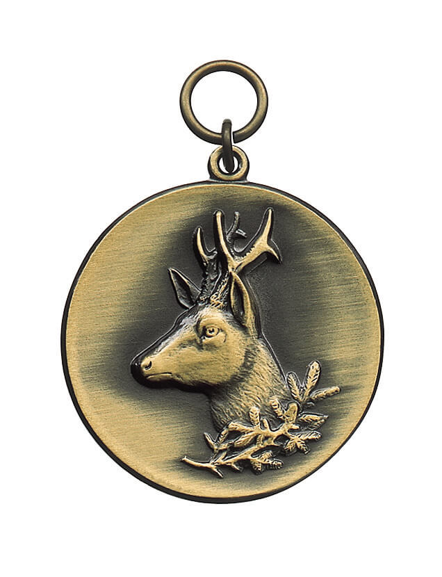 Medaille altsilber mit Öse und Ring, rund mit Rehkopf Runde Medaille altsilber mit Öse und Ring, geprägt mit einem Rehkopf im Profil und Geweih auf glatter Fläche, darunter ein kleiner Eichenzweig.