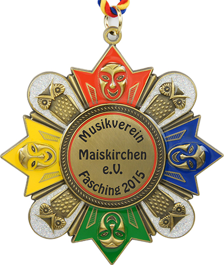 Karnevalsorden Bronze „Maskenball“ – Vorderansicht mit farbigen Maskenmotiven Karnevalsorden Bronze „Maskenball“ in Antikbronze mit roten, gelben, blauen und grünen Maskenmotiven, glitzernden Verzierungen und rot-gelb-blauer Kordel. Mittiger Aufdruck: „Musikverein Maiskirchen e.V. Fasching 2015“.