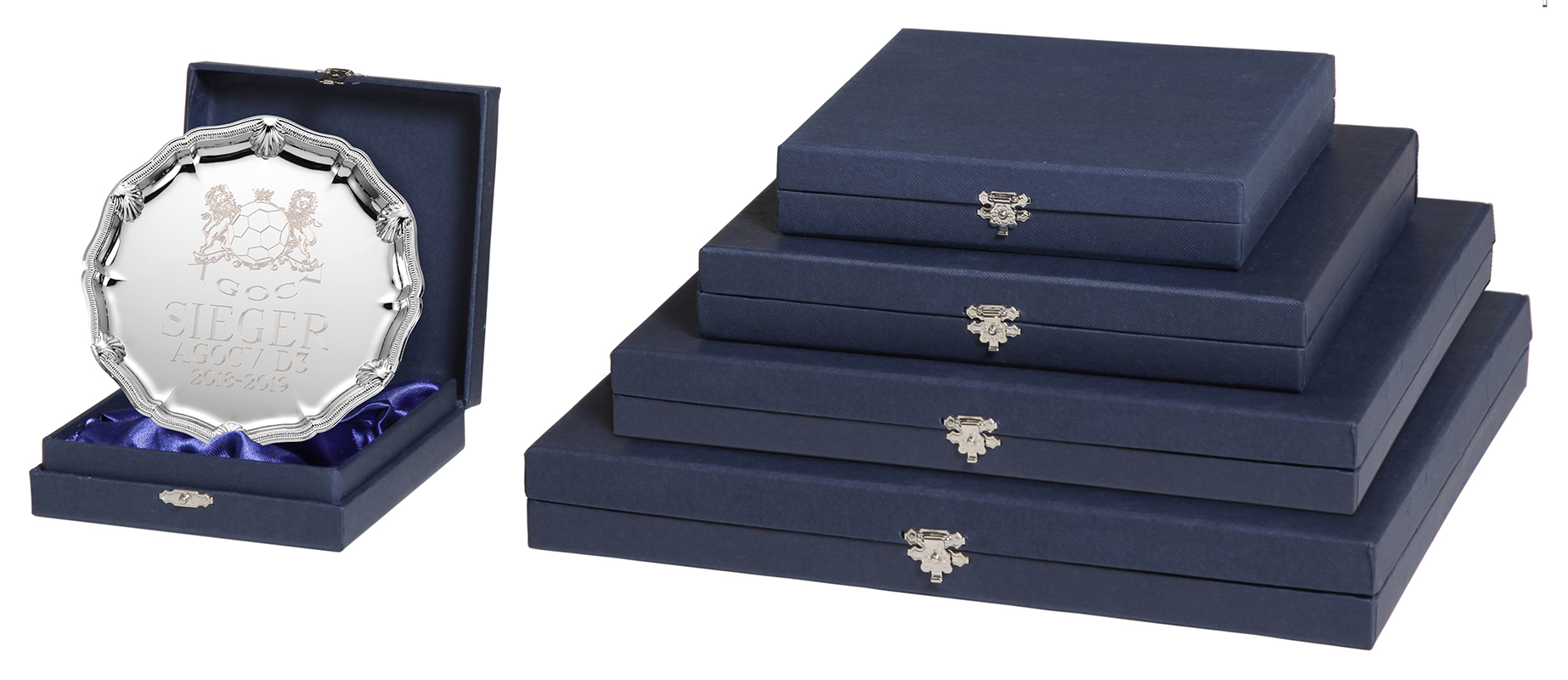 Etui für Ehrenteller 110 x 110 mm in Dunkelblau Dunkelblaues Etui für Ehrenteller 110 x 110 mm mit geöffnetem Deckel, blauem Innenfutter und eingesetztem silberfarbenem Ehrenteller; daneben mehrere geschlossene Etuis in abgestuften Größen.