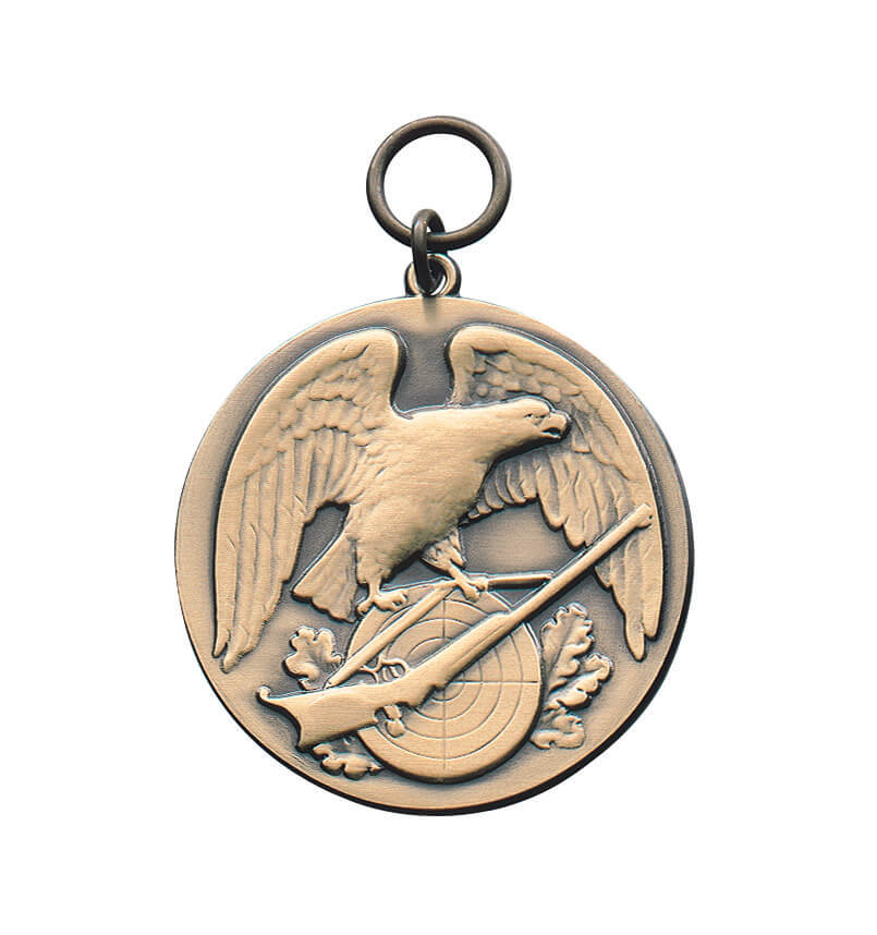 Medaille vergoldet mit Adler, Gewehr und Zielscheibe Runde vergoldete Medaille mit Öse, Adler mit ausgebreiteten Flügeln, Gewehr über einer Zielscheibe und Eichenlaub als Reliefmotiv.