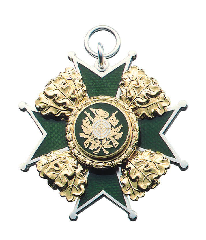 Orden versilbert mit grünem Kreuz, Eichenlaub und Auflage Zielscheibe mit Gewehren Versilberter Orden mit grünem Kreuz, silberfarbenem Rand, vier goldfarbenen Eichenblättern sowie runder Auflage mit Zielscheibe und gekreuzten Gewehren, oben mit Öse und Ring